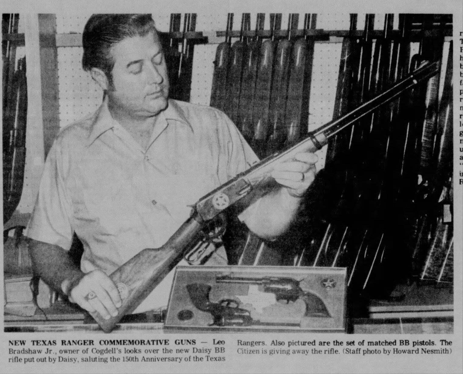 Historic newspaper clipping showing a younger Leo Bradshaw examining a commemorative Daisy rifle honoring the 150th anniversary of the Texas Rangers.